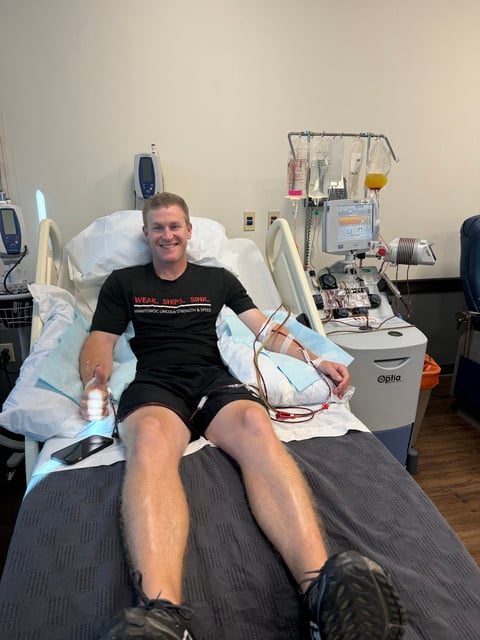 Lincoln teacher/coach Michael Longmeyer smiling in hospital bed during white blood cell donation