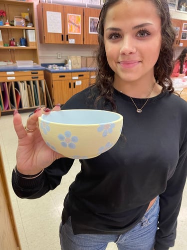 student holding glazed bowl