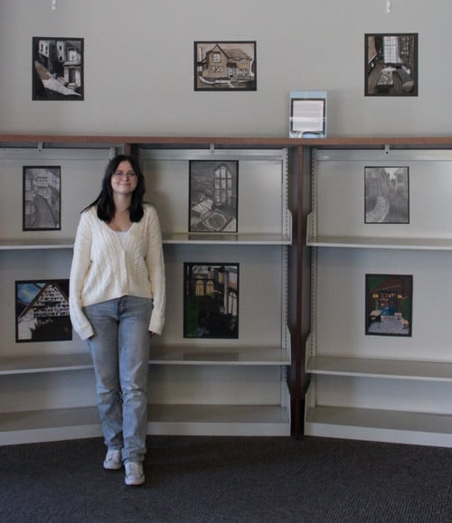 OLIVIA IN FRONT OF HER SHOWCASE AT THE LIBRARY