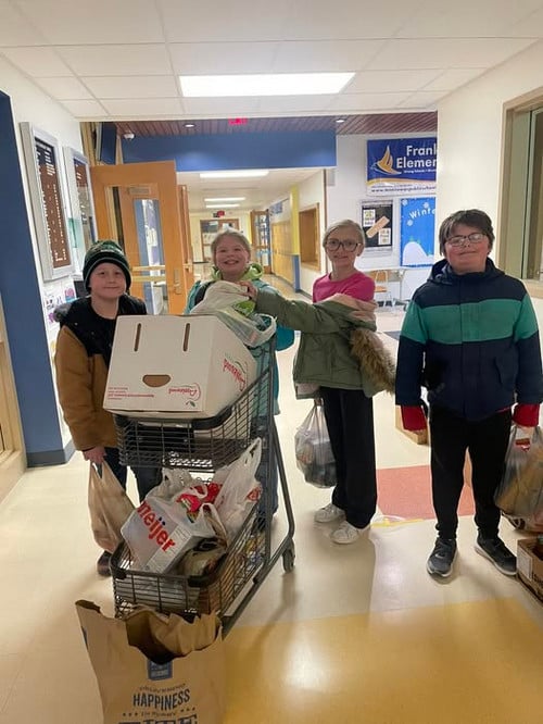 students pushing food donations in a shopping cart