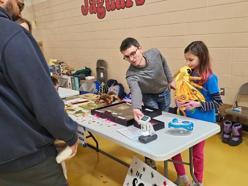 Student booth at STEAM night that features butterflies