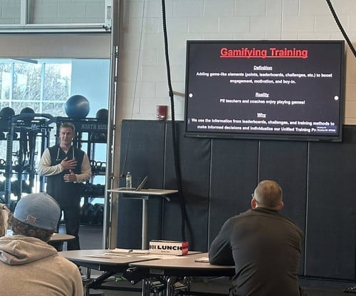 Mike Longmeyer standing in front of a monitor while presenting at the conference