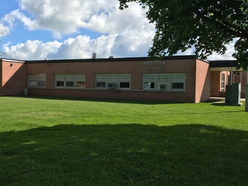 exterior of the Madison Elementary building on a spring day with clouds in the sky