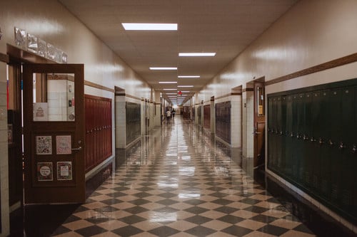 school hallway with students walking into classrooms
