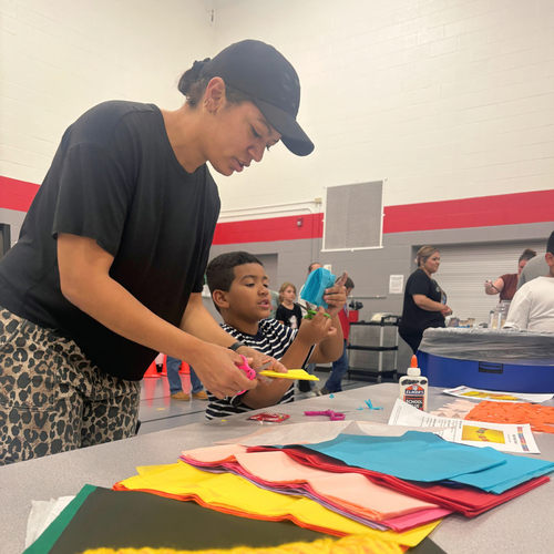 A mother and son make papel picado.