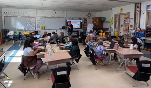 students in class working on typing on their laptops