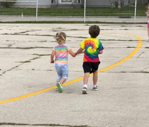 students hold hands while running