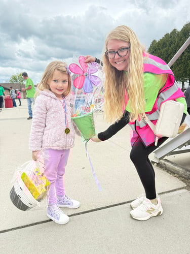 Volunteer hands raffle prize to young girl