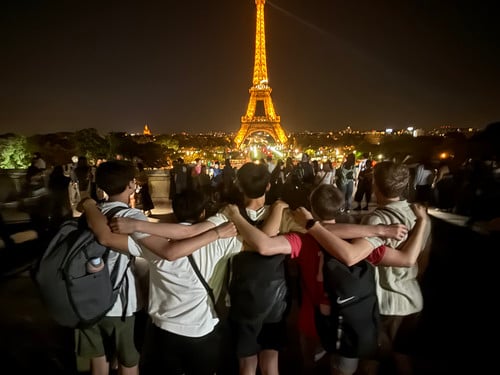 Lincoln students, arms wrapped around each other, stand and look at the Eiffel Tower in Paris