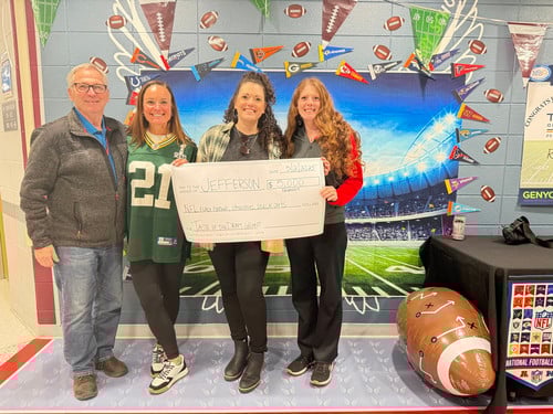 Jefferson Principal holds check from Packers