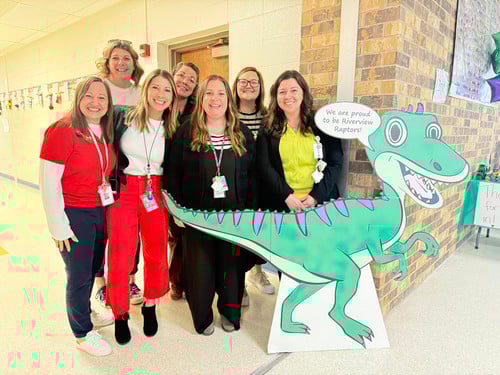 Riverview leaders pose by cardboard Raptor