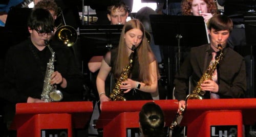 Girl playing saxophone in jazz band