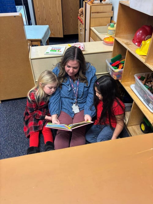 Educator reads to two girls