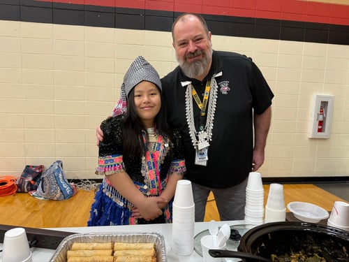 Hmong girl poses in front of her food table