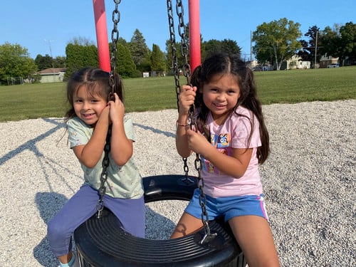Two girls on tire swing